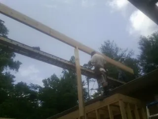 Carpenter setting a ridge beam over a new addition frame — Ice Dam Removal by Roofing Brothers in Hemingway